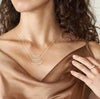 Woman in elegant brown gown wearing the 18K Gold Plated Dainty Zirconia Necklace from NAZ Parure Jewelry.