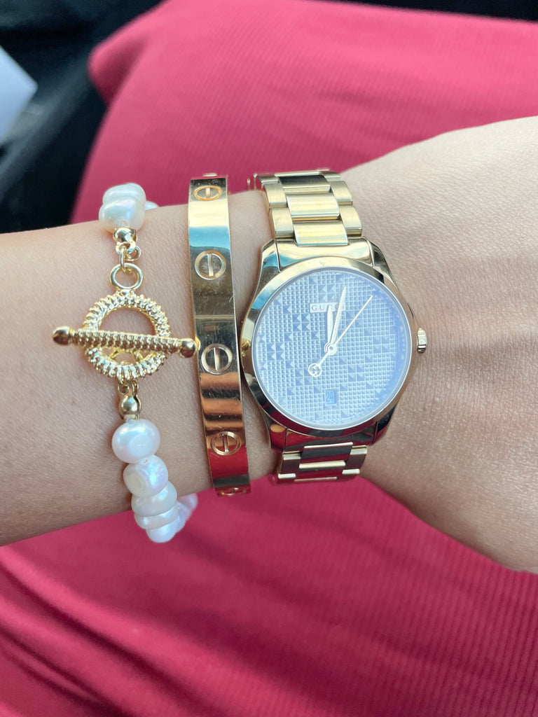 Stacked Parure of Pearls bracelet with Cartier Bangle and Gucci Watch.