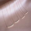 Dainty Zirconia Necklaces laying against pink satin sheet in 2mm size
