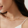 Woman with white thin strap blouse wearing 14K Gold Filled Pearl Pattern Necklace for formal events.