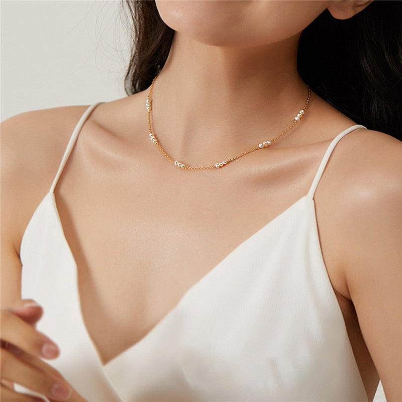 Woman with white low cut thin strap dress wearing 14K Gold-Filled Pearl Pattern Necklace.