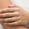 Woman with white blouse wearing 14K gold filled infinity band on middle finger. 