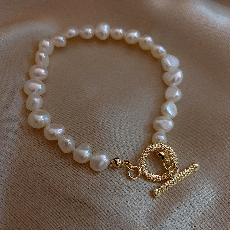 Close up Parure of Pearls Bracelet laying flat on a satin sheet.