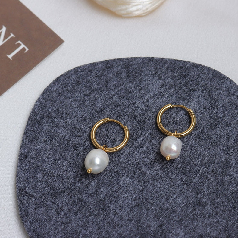 18K gold plated Pearl Drop Gold Hoops on a gray coaster. 