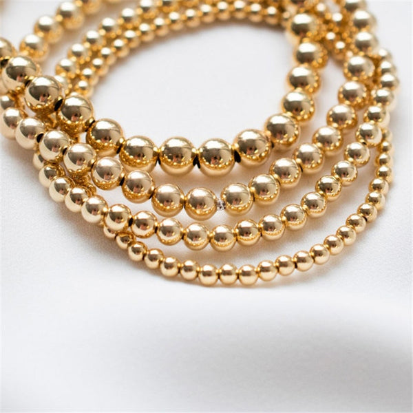 Stackable 14K gold-filled beaded bracelets in 3 different sizes.