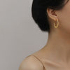 Woman with updo and thin strap blouse wearing Beaded and Solid Hoop Earrings for a special occasion.
