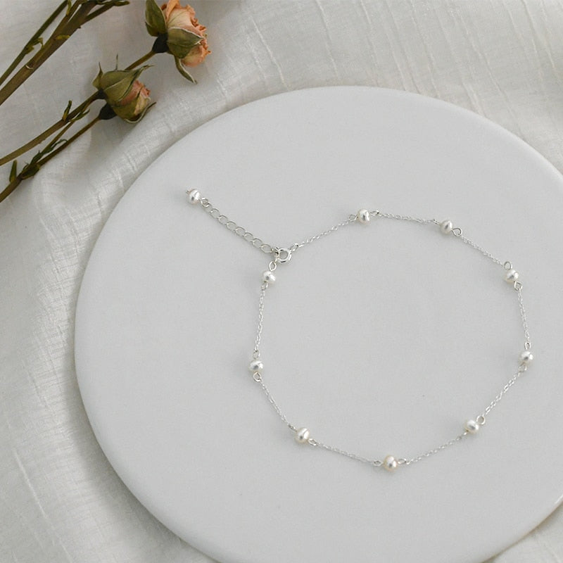 Sterling Pearl Anklet from NAZ Parure resting against white coaster.