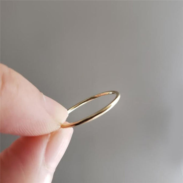 Finger holding one 14K Gold-Filled delicate and dainty Simply Thin Ring.