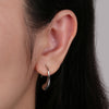 Woman wearing sterling silver Waterdrop Earrings from NAZ Parure.