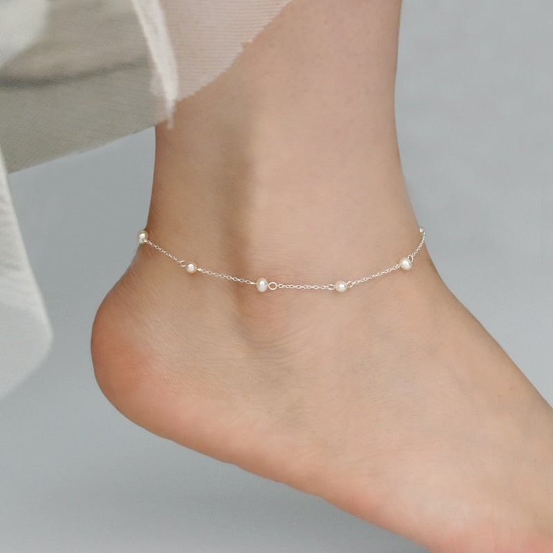 Woman wearing 925 Sterling Pearl Anklet while barefoot from NAZ Parure.