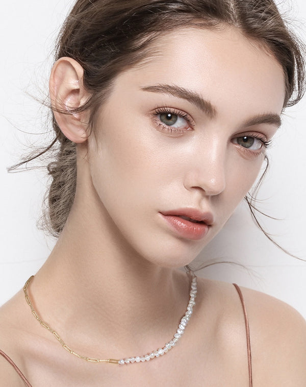 Woman wearing Paperclip Chain with Pearls while showing both the pearls and paperclip. 