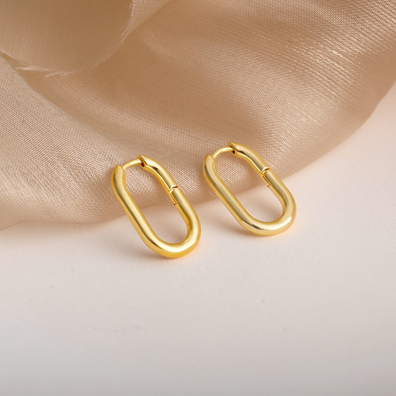 18K gold plated Oval Hoop Earrings against a sheer fabric.