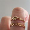 18K gold-filled dainty and delicate knot ring worn above gold chain link ring. 