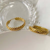 close up of 18K gold wheat hoops on stainless steel.