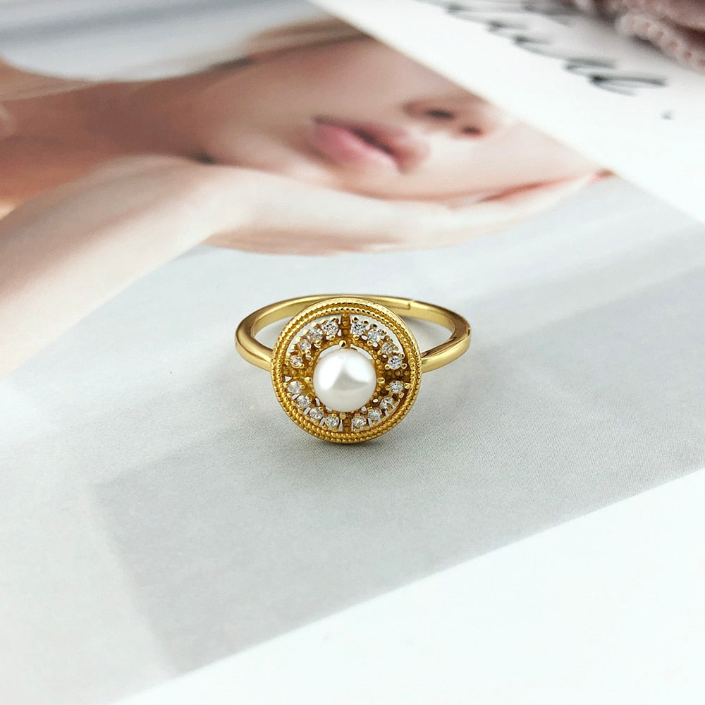14K Gold Plated Freshwater Pearl Ring laying flat on top of a magazine.