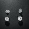 View of sterling silver rhinestone halo studs and push pin against a dark background. 