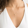 Woman with low cut blouse wearing 14K Gold Filled Zirconia Y necklace from NAZ Parure.