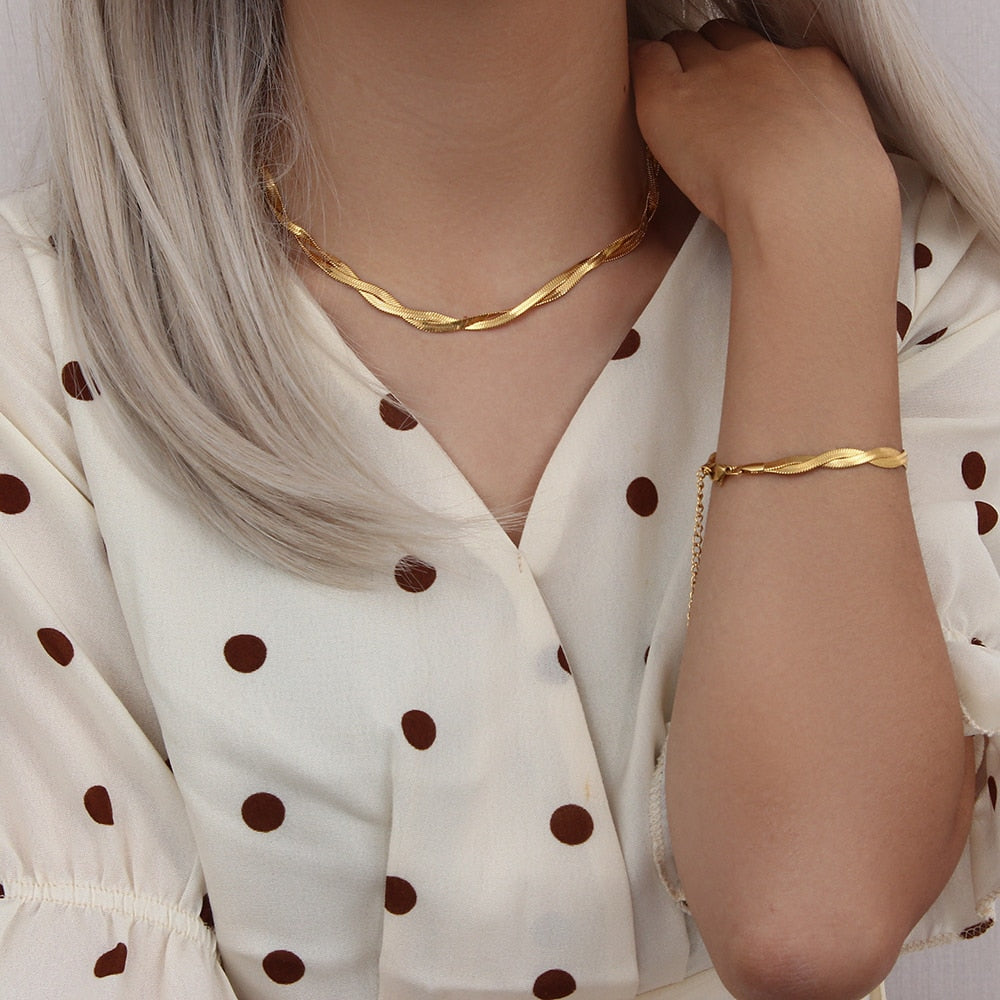 Woman in blonde wearing Gold Braided Chain Necklace and braided bracelet from NAZ Parure Jewelry