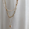 Hanging view of Shell Drop Paperclip Chain, Parure of Pearls choker & Bold Gold Chain from NAZ Parure Jewelry. 