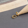Leaves of Gold Earrings on gray and wooden background from NAZ Parure.
