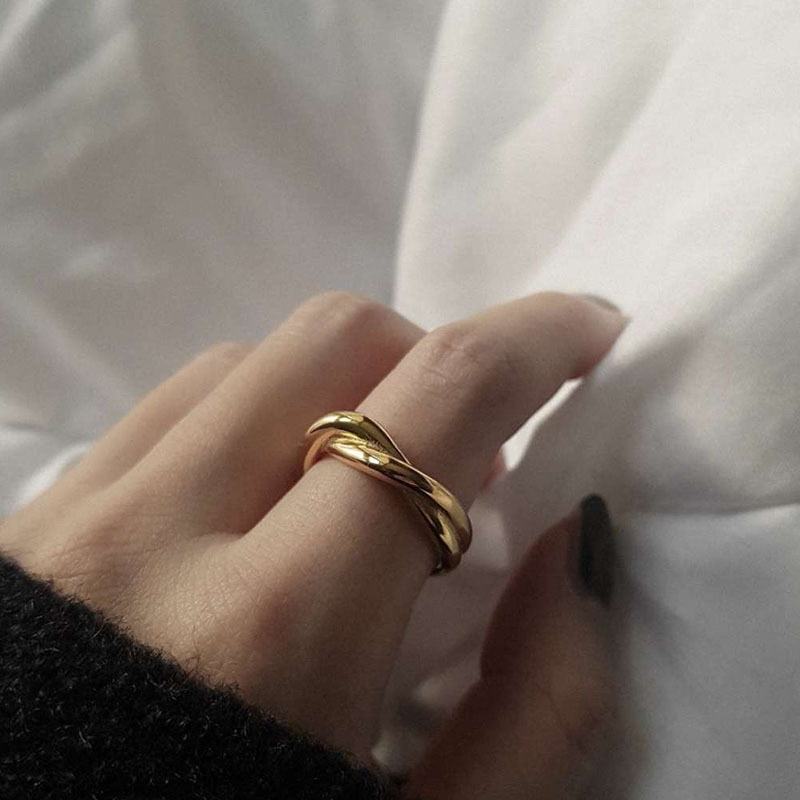 Woman with black sweater wearing 18K gold plated Twist Ring on index finger.