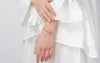 Woman with white ruffle dress wearing 14K Gold vermeil Paperclip Chain Bracelet on left wrist. 