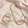 18K Gold Plated Braided Chain Necklace and braided bracelet laid flat against satin sheet