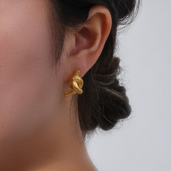 Woman in updo wearing Timeless Knot Gold Studs from NAZ Parure.