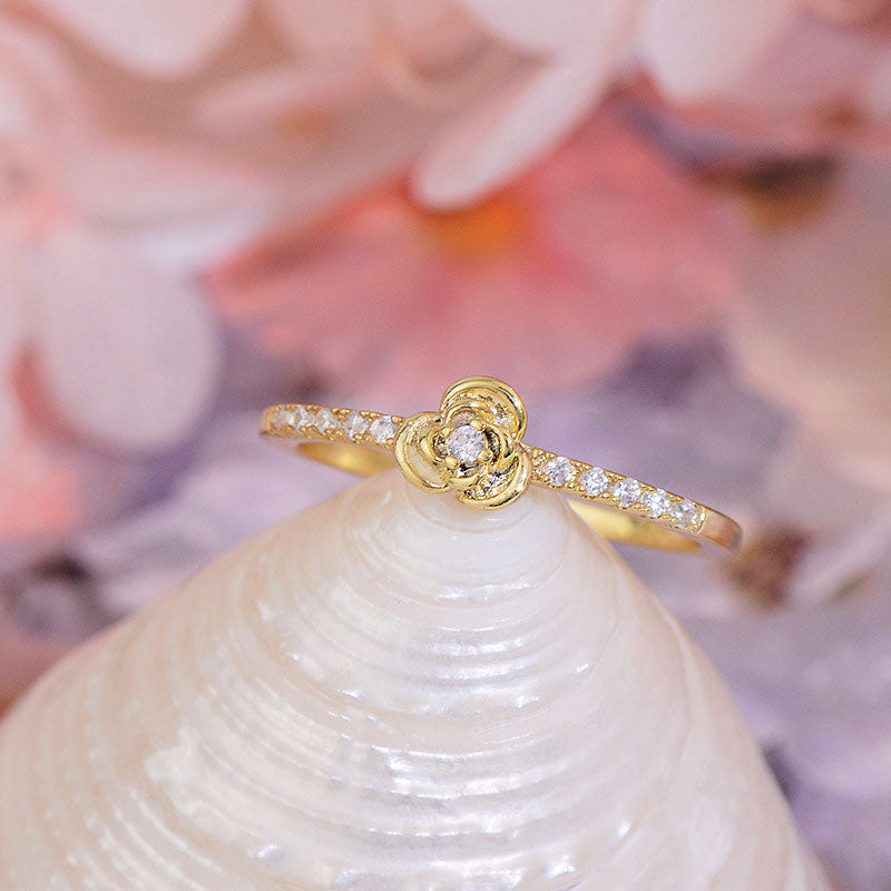 Delicate Rose Ring resting on shell.