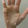 Hand holding dainty Pearl Daisy Necklace - [NAZ Parure]
