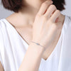 Woman in white sleeveless blouse wearing sterling silver Evil Eye Bracelet by NAZ Parure.