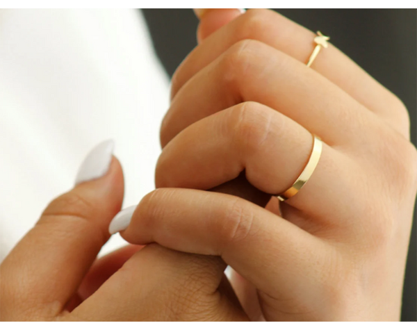 Woman with white nails wearing 14K gold filled infinity band as wedding ring.