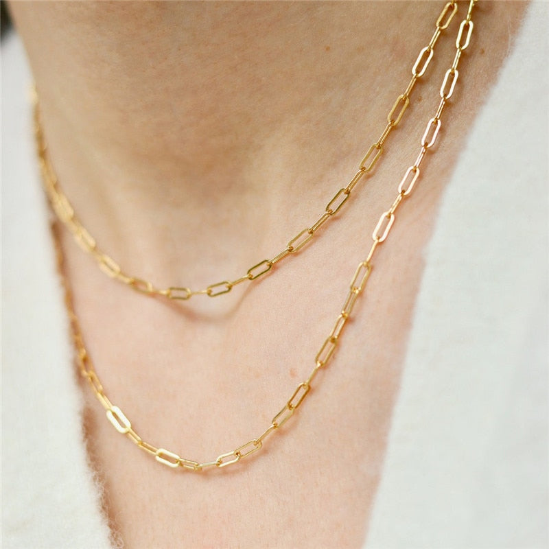 Woman with white low cut cashmere sweater wearing two 14K Gold Filled Oval Link Chains at different lengths.