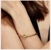 Woman in black dress wearing gold plated Timeless Knot Cuff Bangle.
