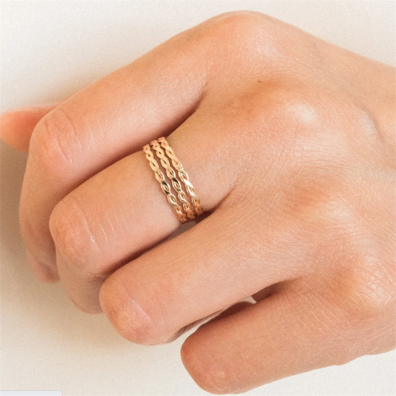 Hand wearing three 14K Gold FIlled Thin Braid rings which are waterproof, sweatproof, hypoallergenic and tarnish-free.
