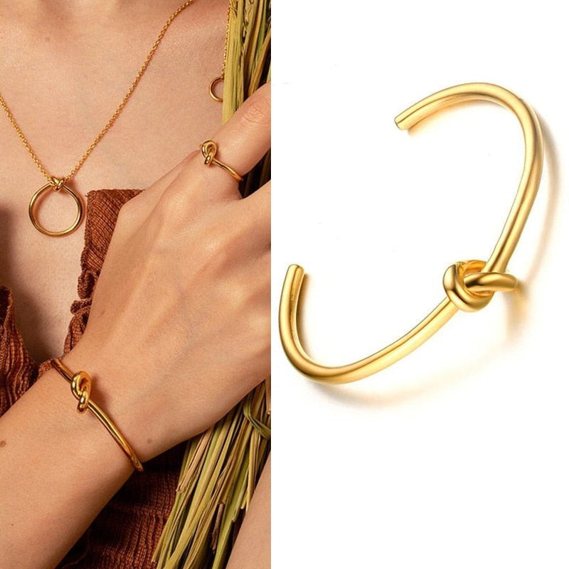 Woman in brown wearing gold plated Timeless Knot Cuff Bangle 