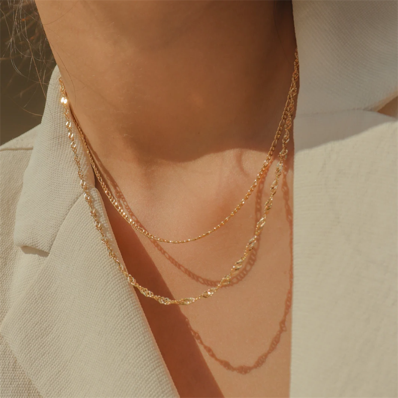 14K Singapore style gold-filled chain which is stacked with a 14K gold-filled figaro necklace. 