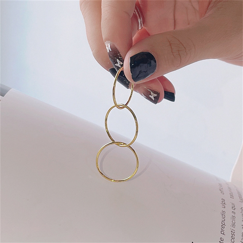 Woman showing the three in one interconnected rings of our 14K gold filled Trinity ring.