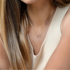 Woman with cream tank top wearing 14k Gold filled Infinity Necklace. 