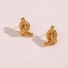Timeless Knot Gold Studs casting shadow on white background.