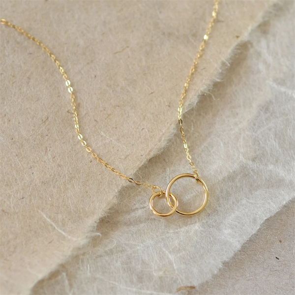 14K Gold filled Infinity Necklace on cream. background