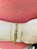 Woman stacking Figaro Link Bracelet, Diamond Bezel Bracelet & Delicate Rose bracelet from NAZ Parure.