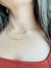 Woman wearing both 14K gold and platinum plated Diamond Bezel Chain from NAZ Parure Jewelry.