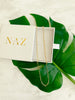 14K Gold-Filled Oval Link Chain resting on top of a NAZ Parure White gift box with palm leaf in background.