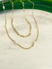 14K Gold Filled Oval Link Chain and Single Pearl Pattern Chain resting on marble counter with green leaves in background.
