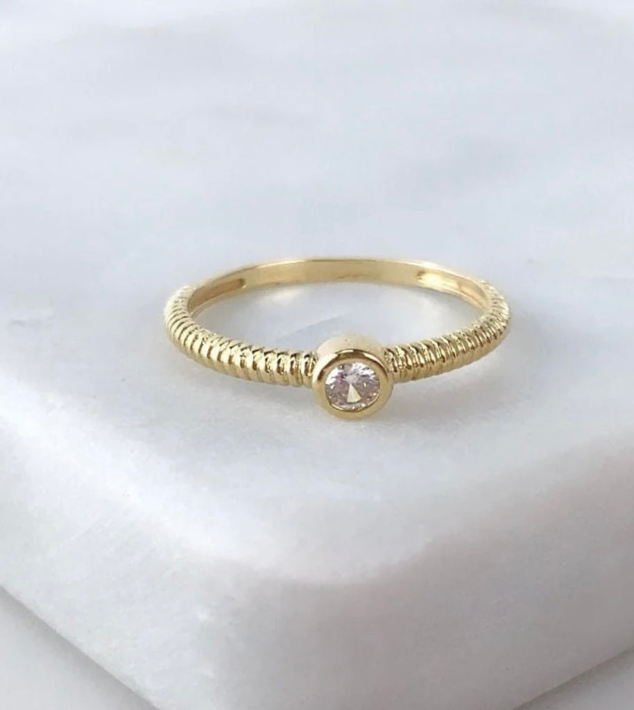 Detailed front view of 18K Gold Filled Spiral DIamond Bezel Ring on white stone.