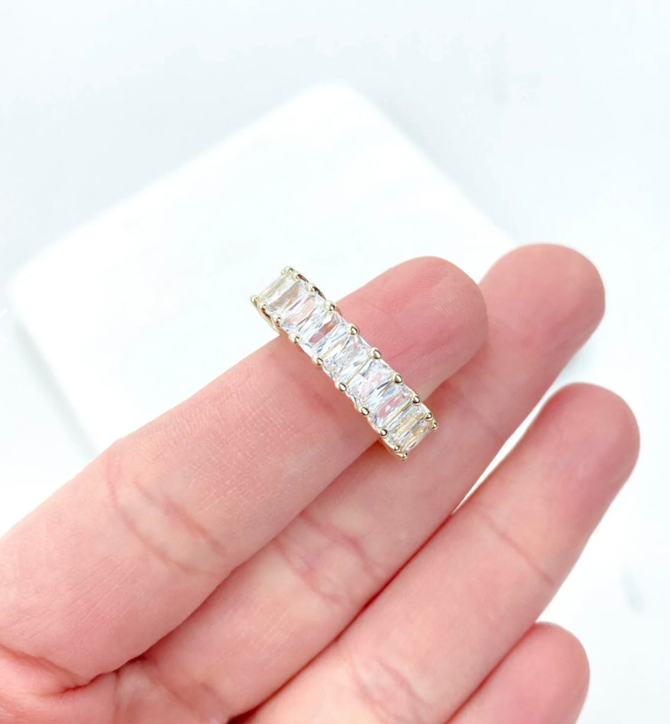 Hand holding 18K gold filled emerald cut ring.