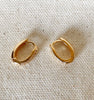 14k Gold FIlled Zirconia Oval huggies laying flat on fabric.