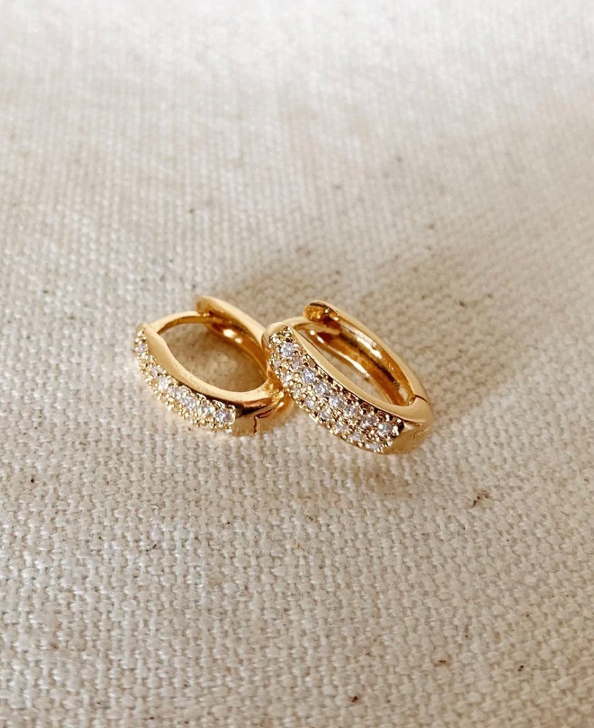 14K Gold FIlled Zirconia Oval Huggies laying against each other.