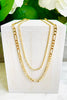 Thin and Classic 18K Gold FIlled FIgaro Chain on white wooden block with greenery in background.